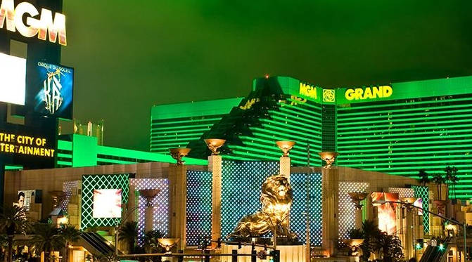 The beatufiul MGM Grand Hotel and Casino at night against a neon-lit sky.